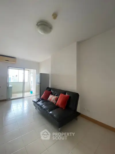 Spacious living room with modern sofa and balcony access in a bright apartment.