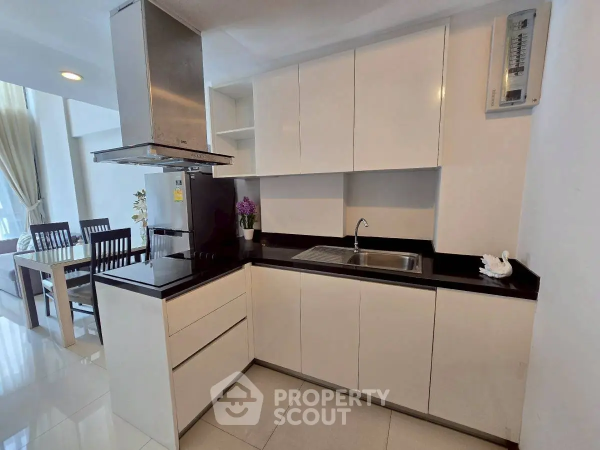 Modern kitchen with sleek cabinetry and dining area in a stylish apartment.