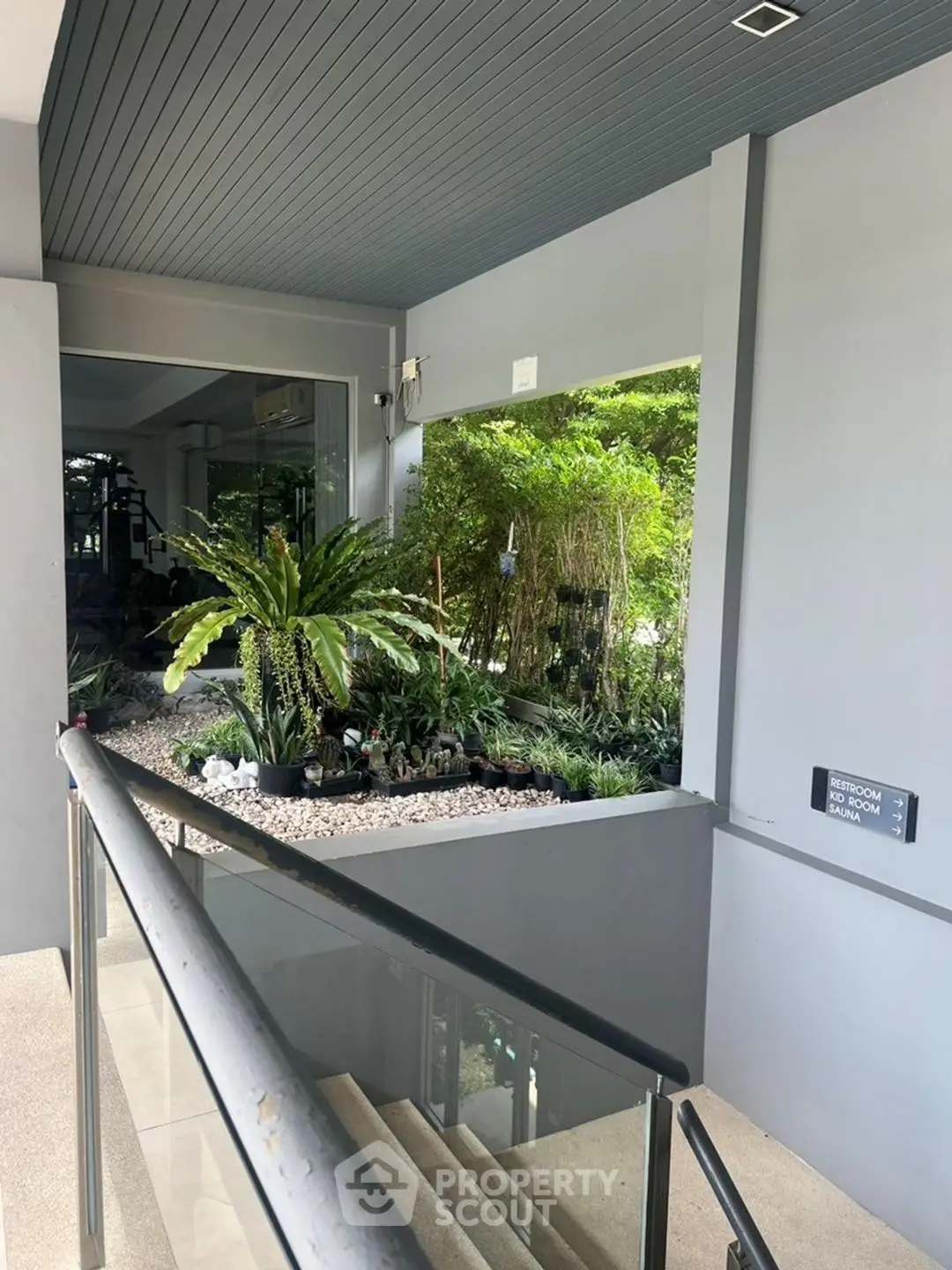 Modern building entrance with lush indoor garden and sleek design