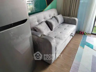 Modern living room with plush gray sofa and sleek refrigerator