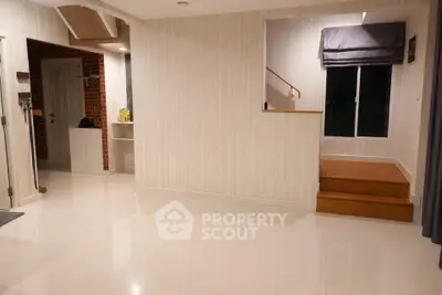 Spacious modern living area with sleek flooring and stylish staircase