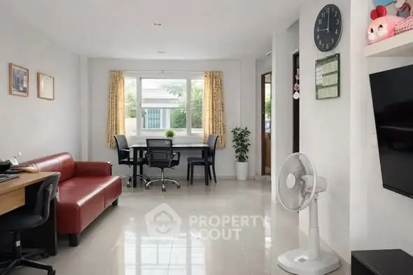 Spacious living room with modern furniture and large window for natural light.