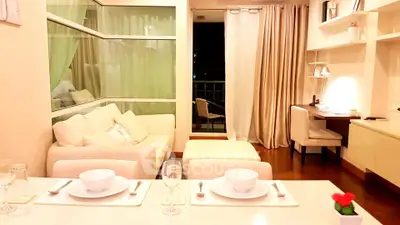 Modern living room with elegant dining setup and cozy workspace, featuring a stylish open layout and warm lighting.