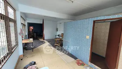 Spacious room with large windows and tiled wall, ideal for creative renovation.