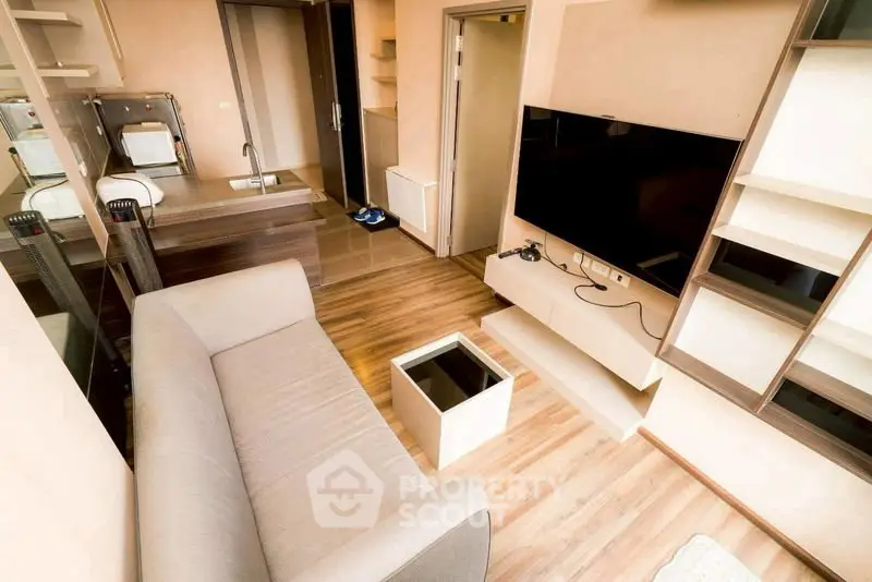 Modern living room with sleek furniture and wall-mounted TV in a cozy apartment.