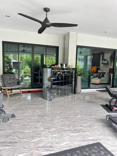 Spacious modern living area with large windows and sleek decor, perfect for relaxation and entertainment.
