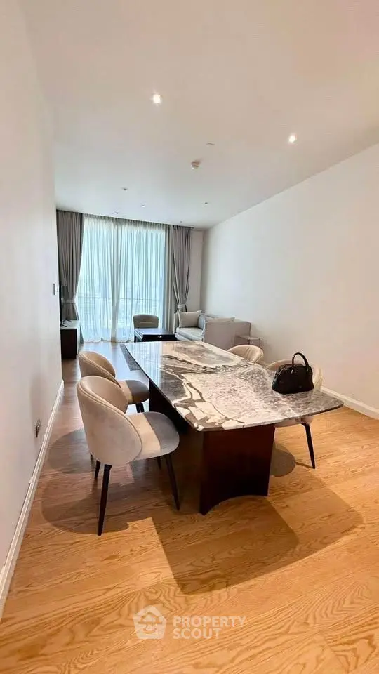 Elegant dining area with marble table and plush chairs in a modern apartment.