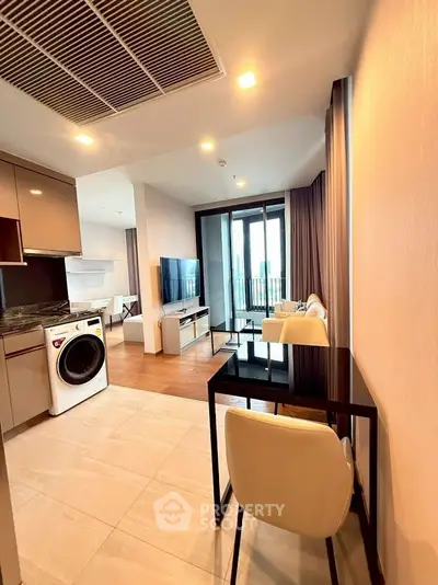 Modern apartment interior with open layout, featuring a sleek kitchen, cozy living area, and balcony access.
