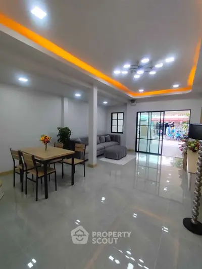Spacious modern living room with sleek lighting and open layout, perfect for entertaining.