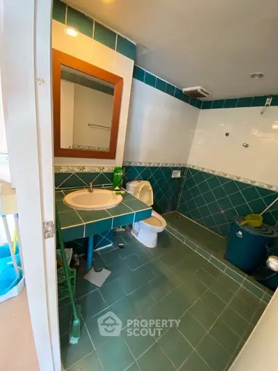 Spacious bathroom with teal tiles and modern fixtures