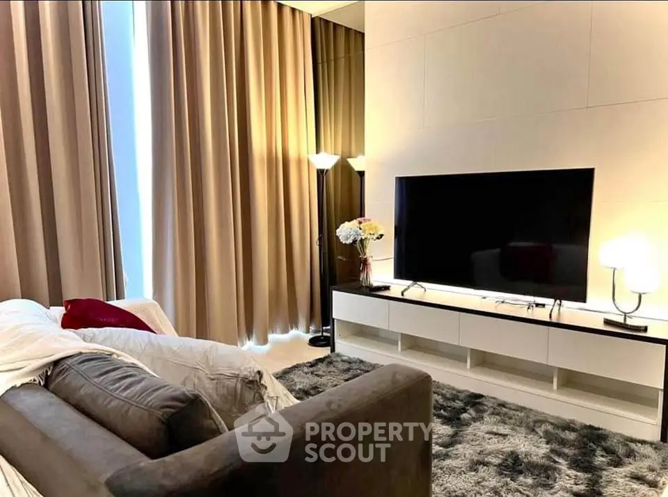 Luxurious living room with plush sofa, large TV, and elegant decor in modern apartment.