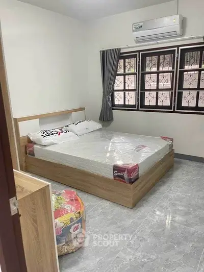 Cozy bedroom with modern furnishings and air conditioning, perfect for comfortable living.