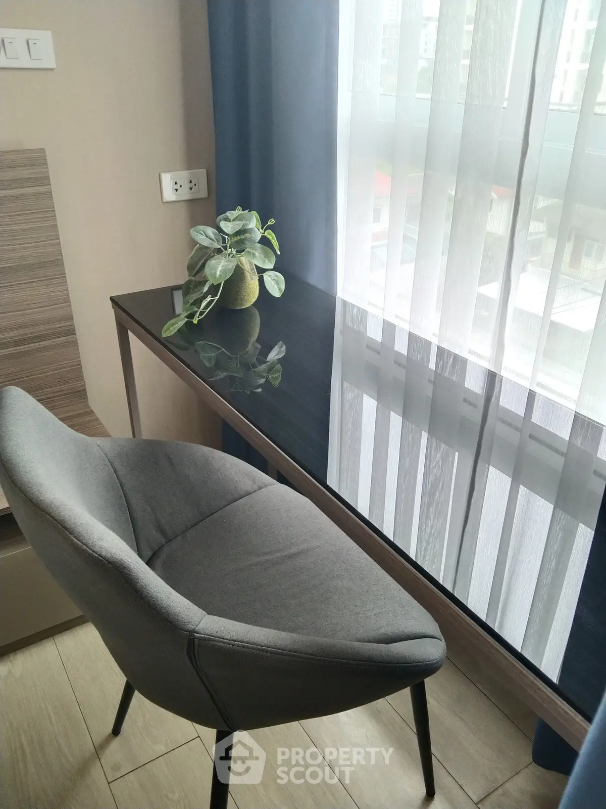 Modern study area with sleek desk and stylish chair by a bright window.