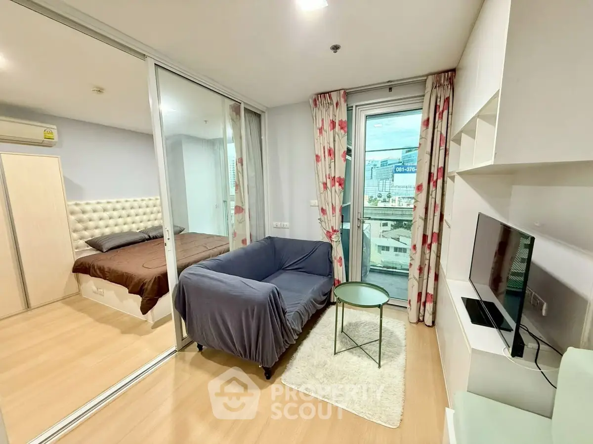 Modern living room with cozy sofa, TV, and balcony view in a stylish apartment