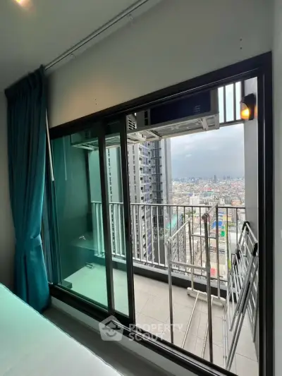 Modern high-rise apartment with balcony offering stunning cityscape views, featuring floor-to-ceiling windows and sleek design.