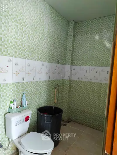 Spacious bathroom with green mosaic tiles and modern fixtures