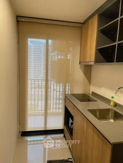 Modern kitchen with sleek design and balcony view in urban apartment