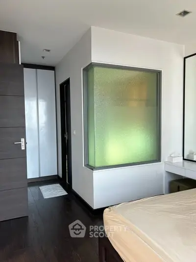 Modern bedroom with frosted glass feature and sleek wooden flooring