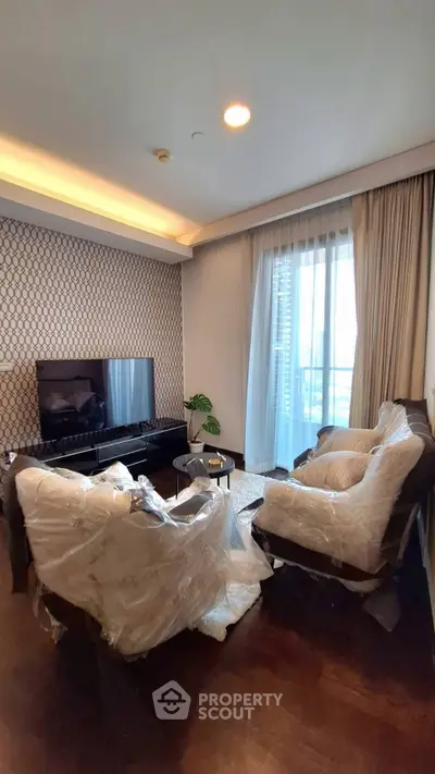 Modern living room with stylish decor and natural light, featuring a cozy seating area and elegant wallpaper.