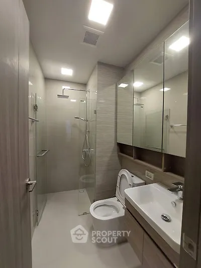 Modern bathroom with glass shower and sleek fixtures in a contemporary apartment.
