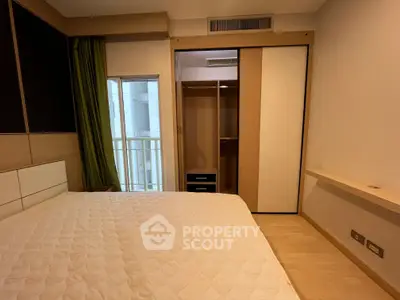 Cozy bedroom with built-in wardrobe and balcony access in modern apartment