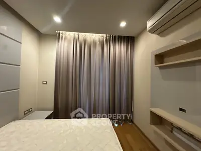 Modern bedroom with sleek design, featuring air conditioning and elegant curtains for a cozy ambiance.