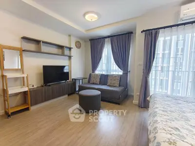 Modern living room with stylish decor and natural light, featuring a cozy sofa and entertainment center.