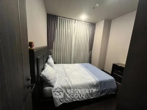 Cozy bedroom with elegant curtains and soft lighting, perfect for relaxation.