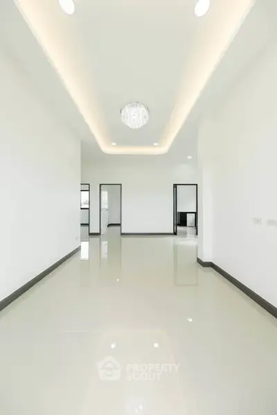 Spacious modern living room with elegant ceiling light and glossy tiled floor