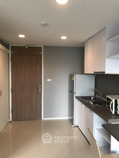 Modern kitchen with sleek cabinetry and stainless steel appliances in a compact layout.