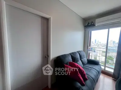 Cozy living room with city view, featuring a comfortable sofa and air conditioning.