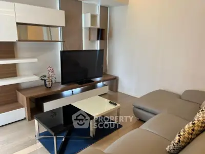Modern living room with sleek furniture and large TV, perfect for relaxation.