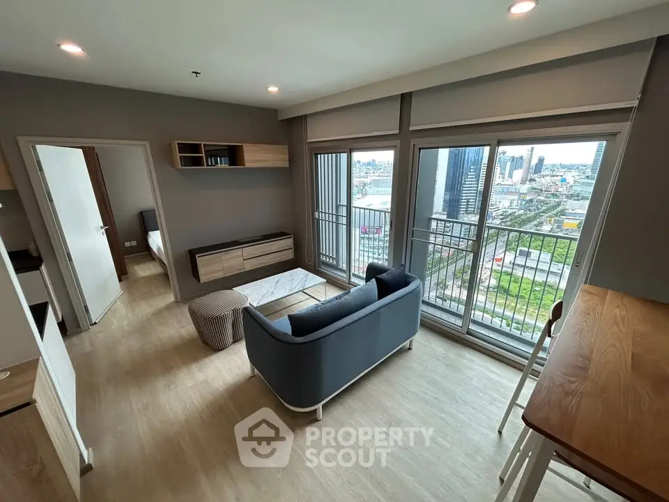 Modern living room with city view, stylish furniture, and large windows for natural light.