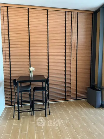 Modern dining area with wooden blinds and sleek furniture in a stylish apartment.