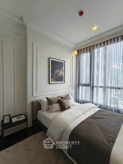 Luxurious bedroom with elegant decor and large windows offering stunning city views.