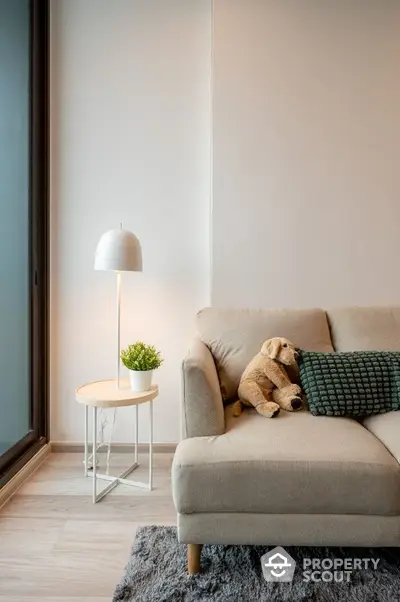 Cozy living room with modern sofa, plush toy, and stylish lamp for a warm ambiance.