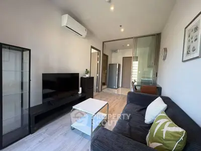 Modern living room with sleek furniture and open layout, featuring a cozy sofa and wall-mounted TV.
