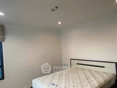 Spacious bedroom with cozy lighting and a comfortable mattress