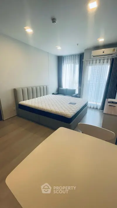 Modern bedroom with large bed and natural light in stylish apartment