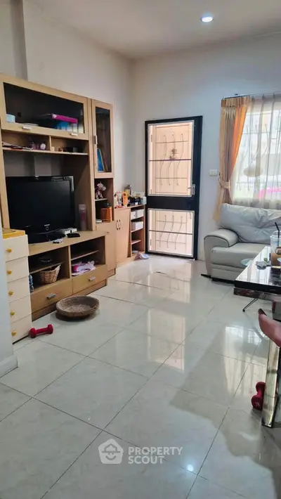 Cozy living room with modern furniture and natural light, perfect for relaxation and entertainment.