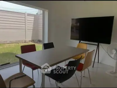 Modern study room with large window and stylish chairs, perfect for meetings or remote work.