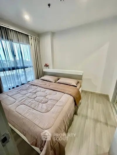 Cozy bedroom with modern decor and large window for natural light