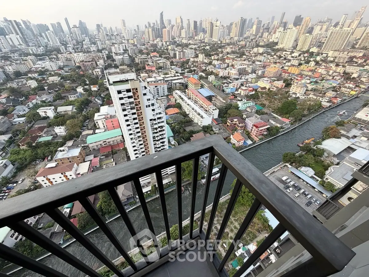 Stunning high-rise balcony view of city skyline and river below