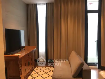 Cozy living room with modern sofa and TV, featuring elegant curtains and wooden furniture.