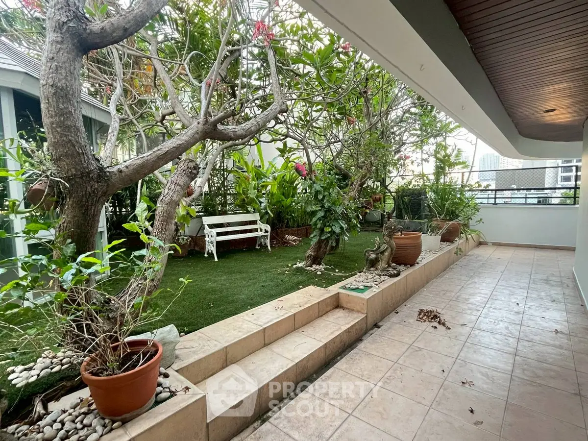 Charming garden terrace with lush greenery and cozy seating area, perfect for relaxation and outdoor enjoyment.