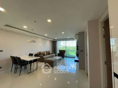 Spacious modern living room with dining area and large windows offering a scenic view.