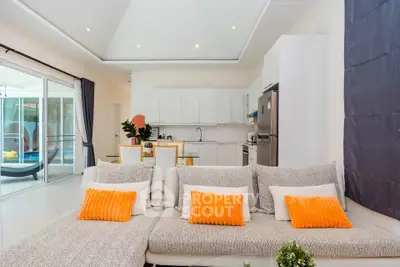 Modern open-plan living room with sleek kitchen and bright decor