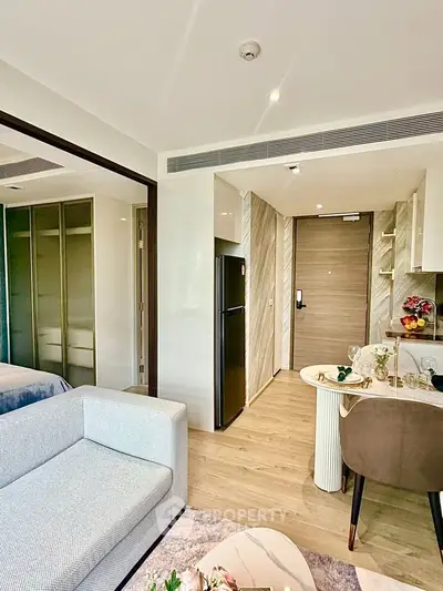Modern apartment interior with open layout, featuring a cozy living area and sleek kitchen design.