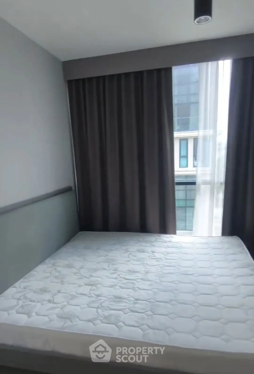 Modern bedroom with large window and stylish curtains in urban apartment