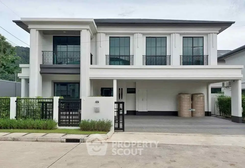 Elegant two-story modern house with large windows and spacious driveway